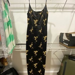 Long black dress with gold Asian detail.